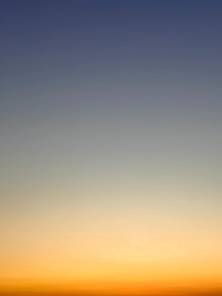 Dusk sky showing a natural color gradient from blue to yellow. Serene and peaceful atmospheric background.